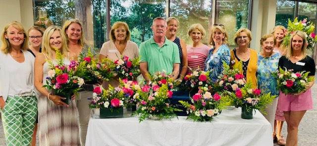 group of women and man around floral arrangements