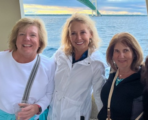 women on boat in front of bridge