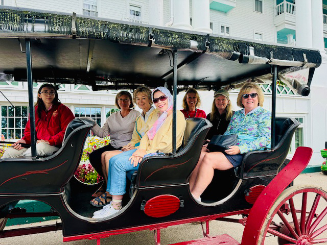 women riding on horse drawn carriage