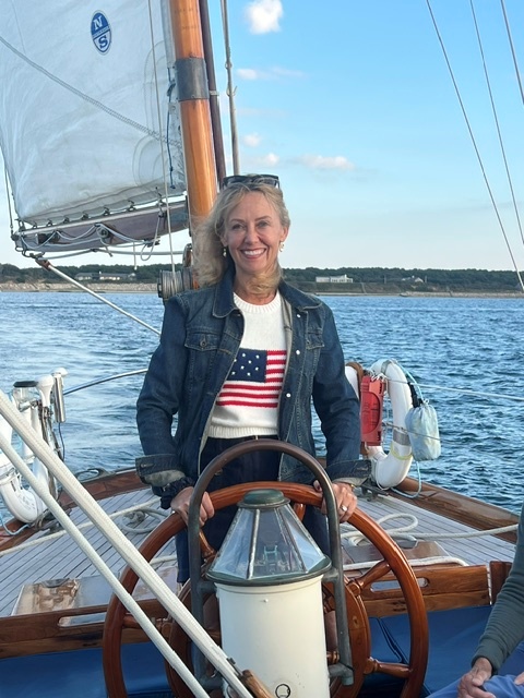 women in american flag shirt steering ship
